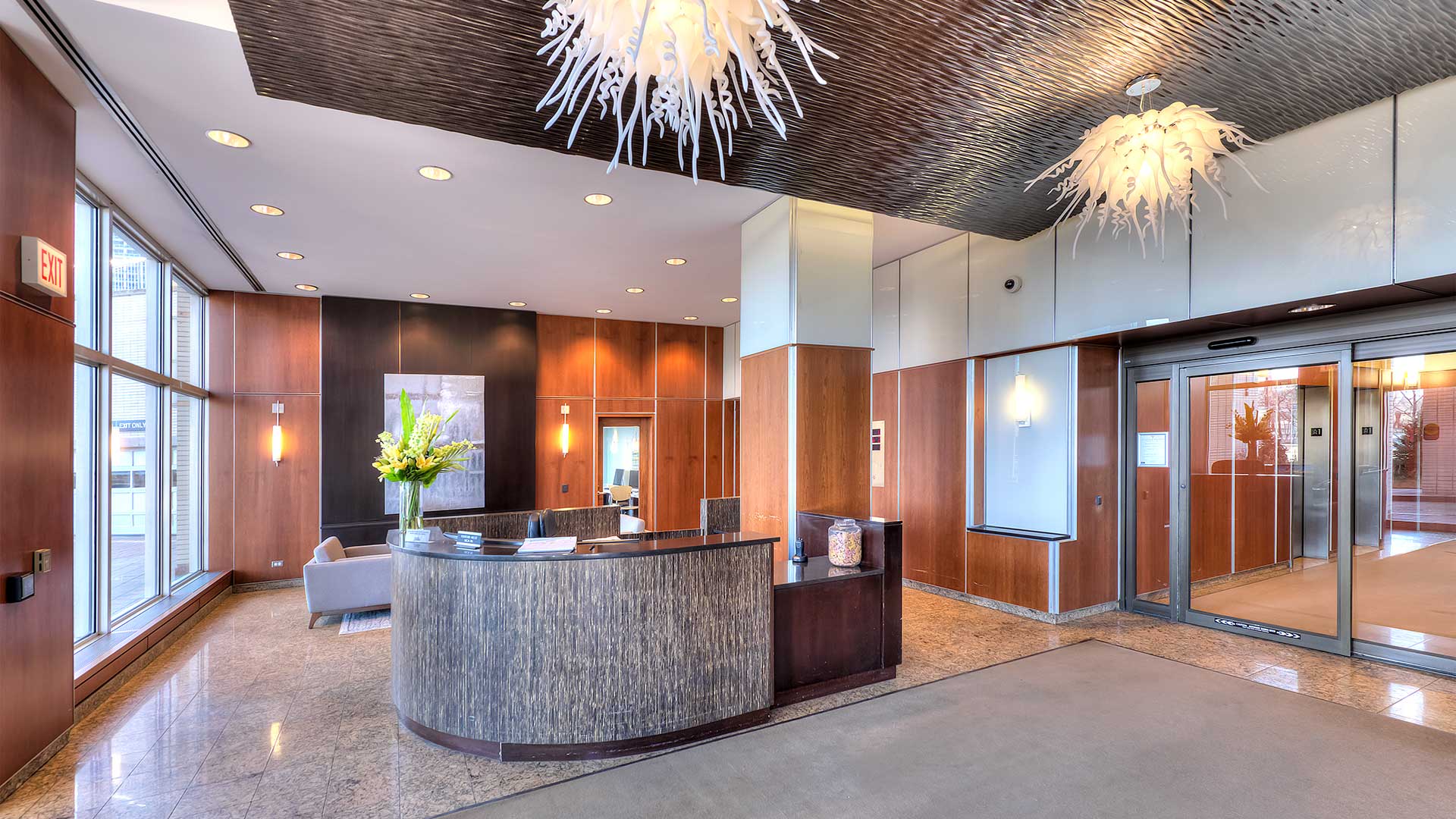 The lobby at Eleven Thirty. The front desk is in the center and a guest waiting area is behind it. The doors to the elevator lobby are seen on the right.